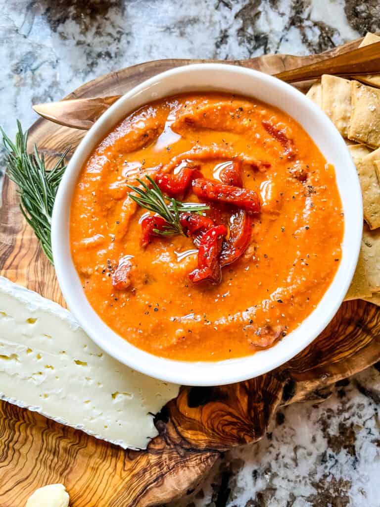 Bowl of Hummus with Red Pepper on a charcuterie board