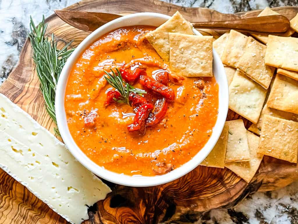 Bowl of the dip with crackers in it on a cheese board