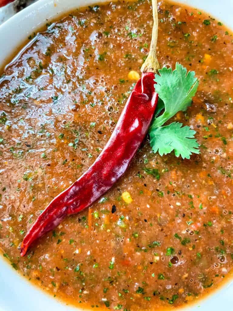 Close up of Salsa Chile de Arbol with a pepper on top