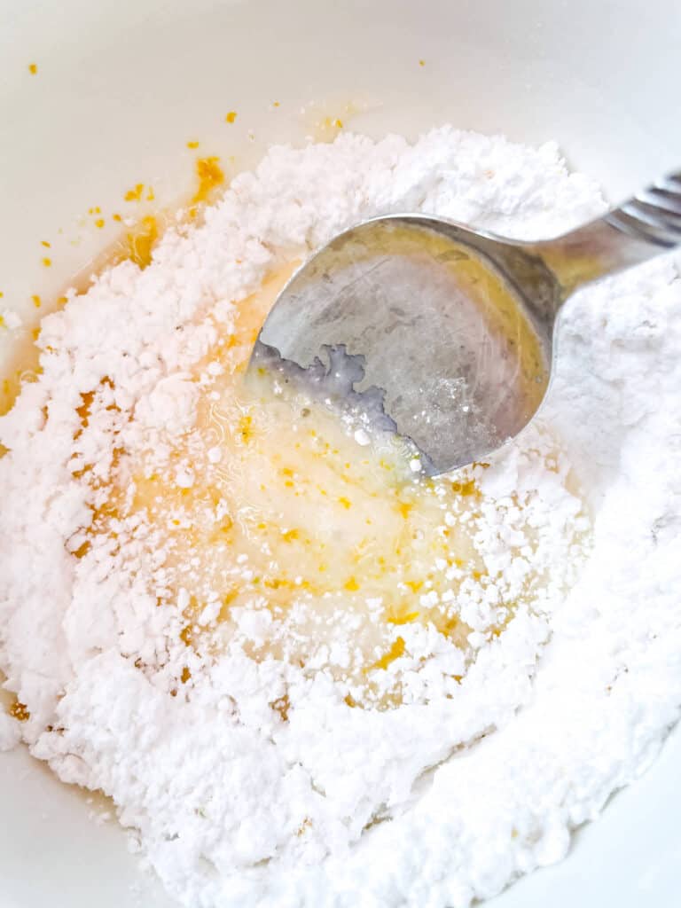 A spoon mixing all of the ingredients together in a white bowl