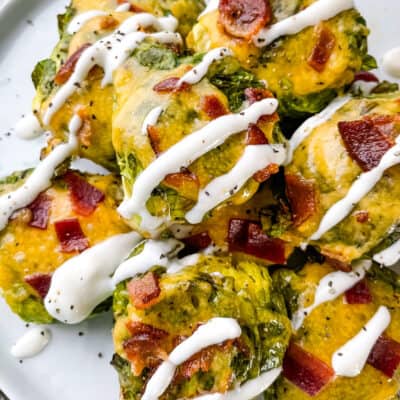 A pile of Loaded Smashed Brussels Sprouts drizzled with sour cream