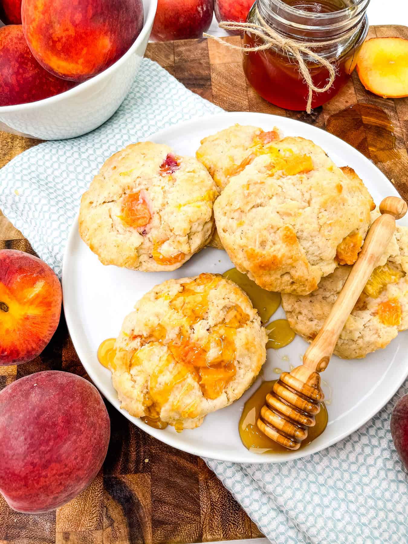 Peach Scones on a white plate with a honey wand