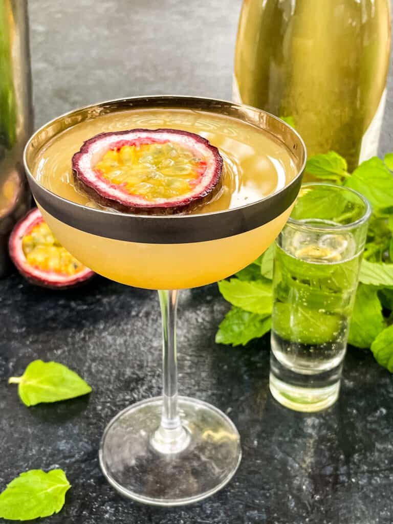 A glass of Pornstar Martini with mint behind it