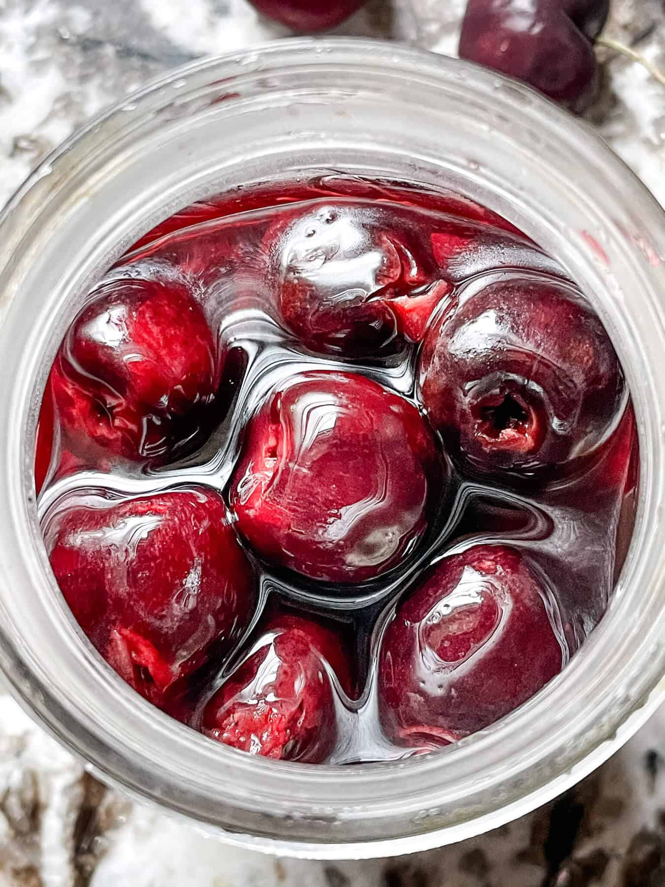 Top view of a jar full of Brandied Cherries