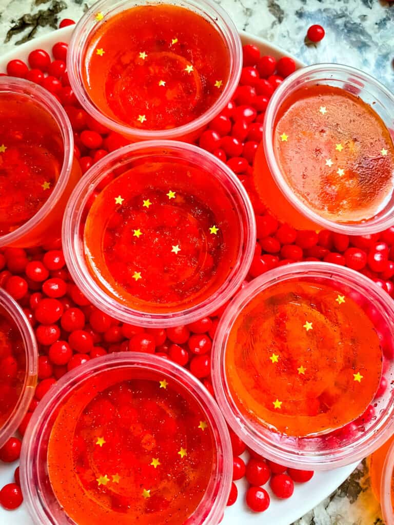 Top view of some filled cups on top of red candy