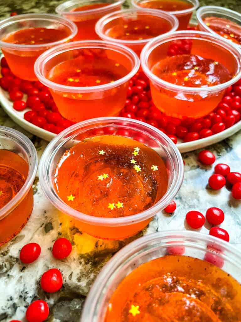 The cups spread out on a counter and plate with red candies