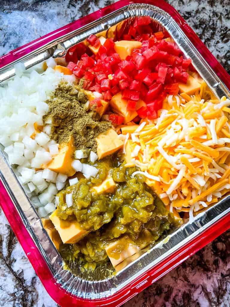 The ingredients for Smoked Queso in a foil pan before cooking