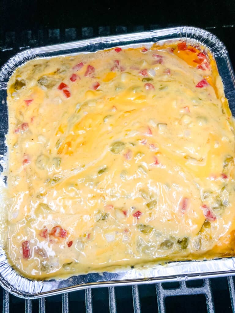 A pan of melted Smoked Queso on the smoker