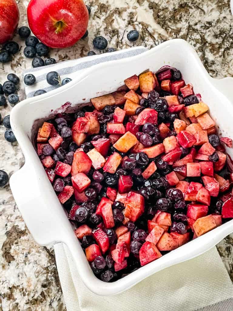 The fruit layer of the dessert in a white square dish