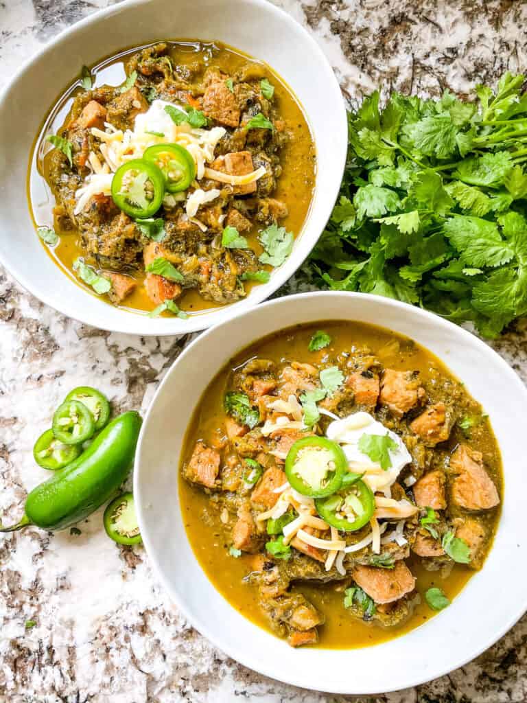 Two white bowls full of Hatch Pork Green Chili