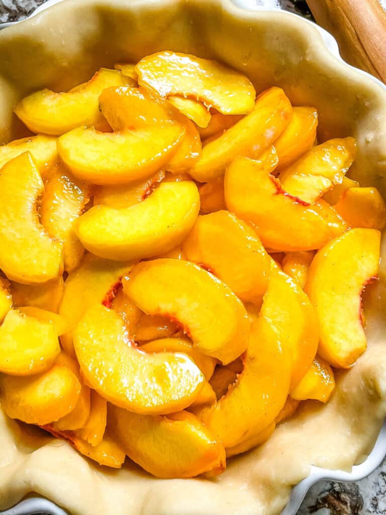 Close up of peach pie filling in the crust