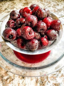 Cherries being strained into a bowl