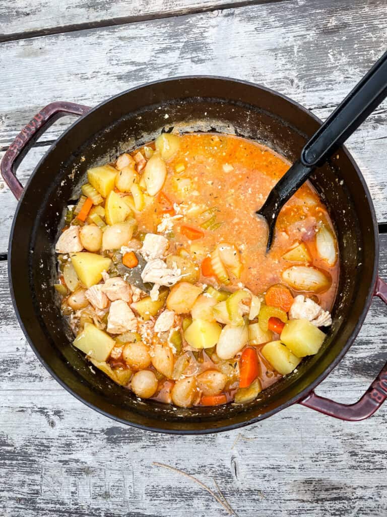 A pot of Chicken Campfire Stew on the picnic table from top view