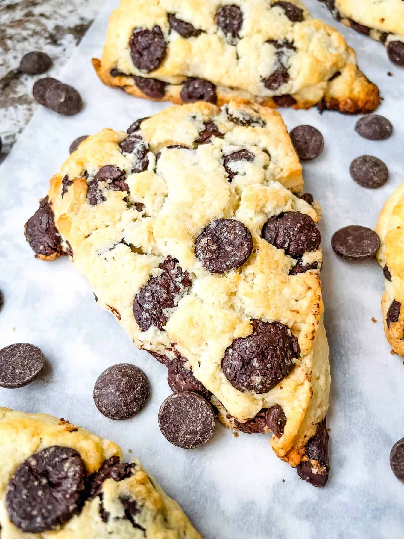 One pastry on parchment with chocolate chips around it