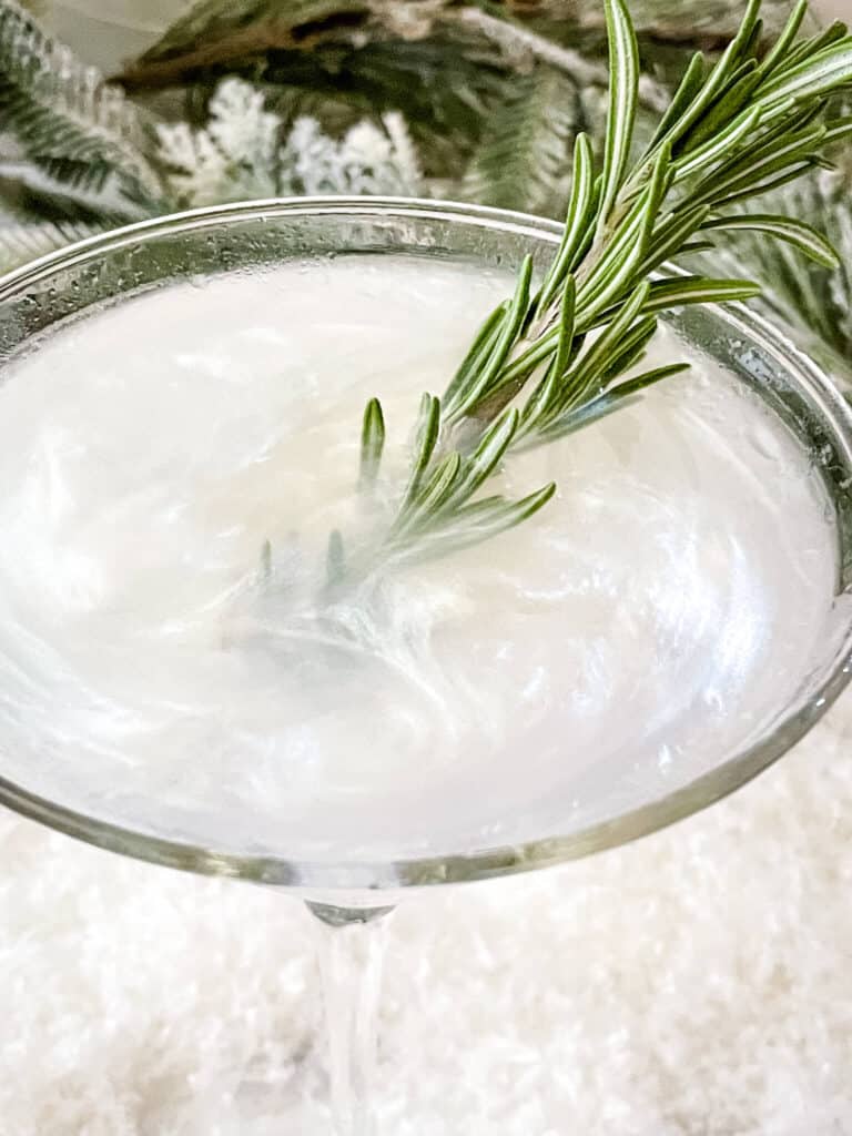 Top view of the swirly white drink with rosemary in it