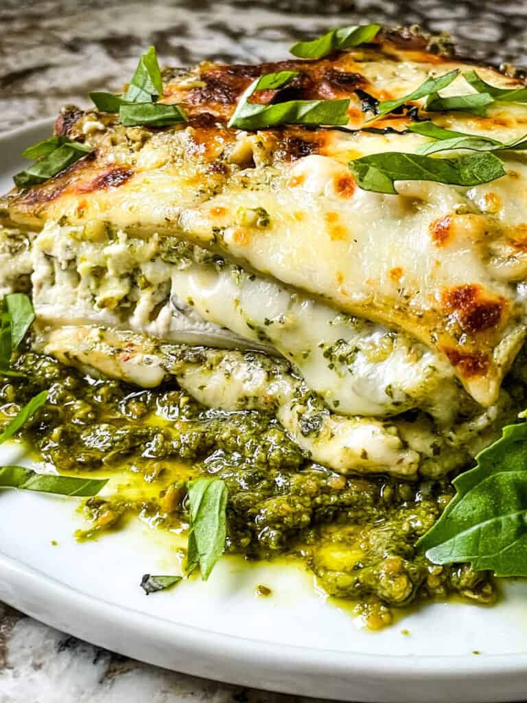 Side view of a slice of Lasagna al Pesto on a white plate