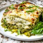 Side view of Lasagna al Pesto on a plate with dresh basil