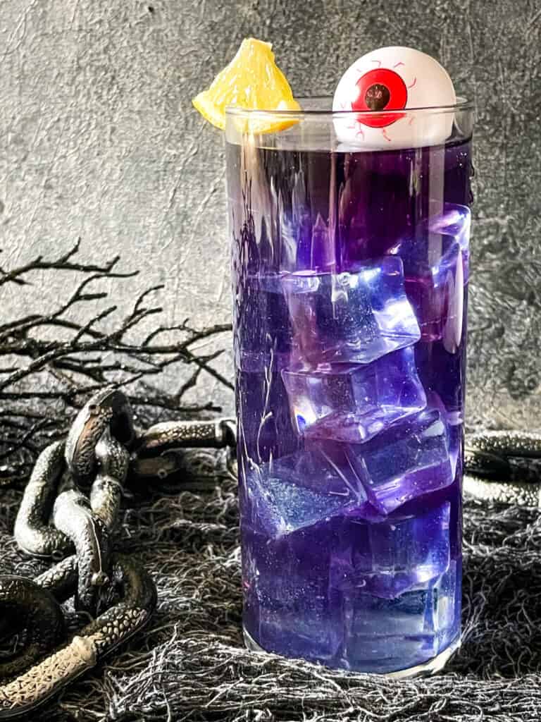 A tall Purple People Eater Halloween Cocktail (+Mocktail)