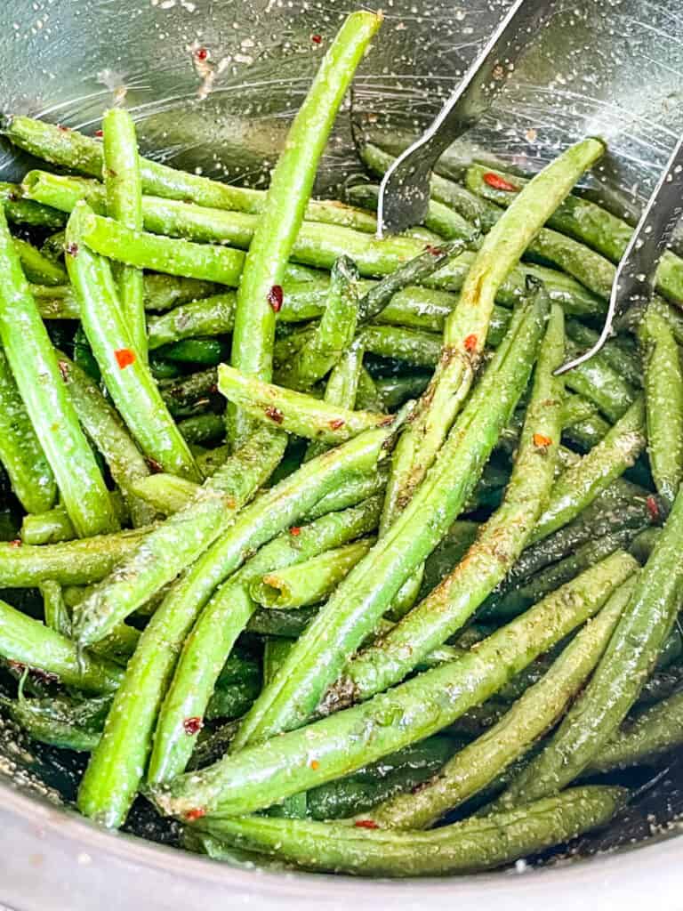 Spicy Asian Air Fryer Green Beans being tossed before cooking