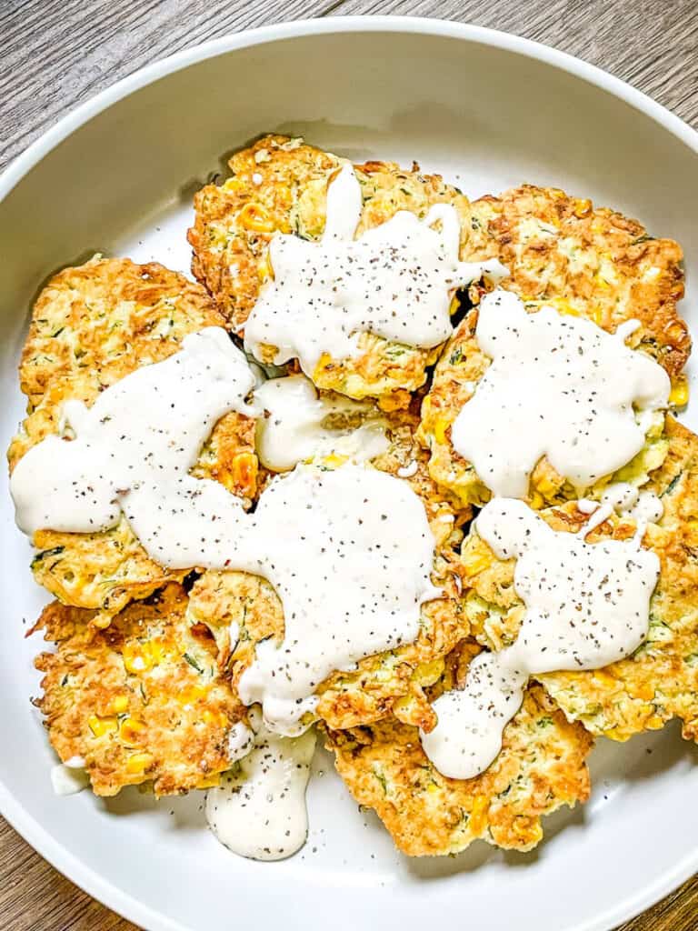 Corn and Zucchini Fritters with White Gravy on top in a large bowl