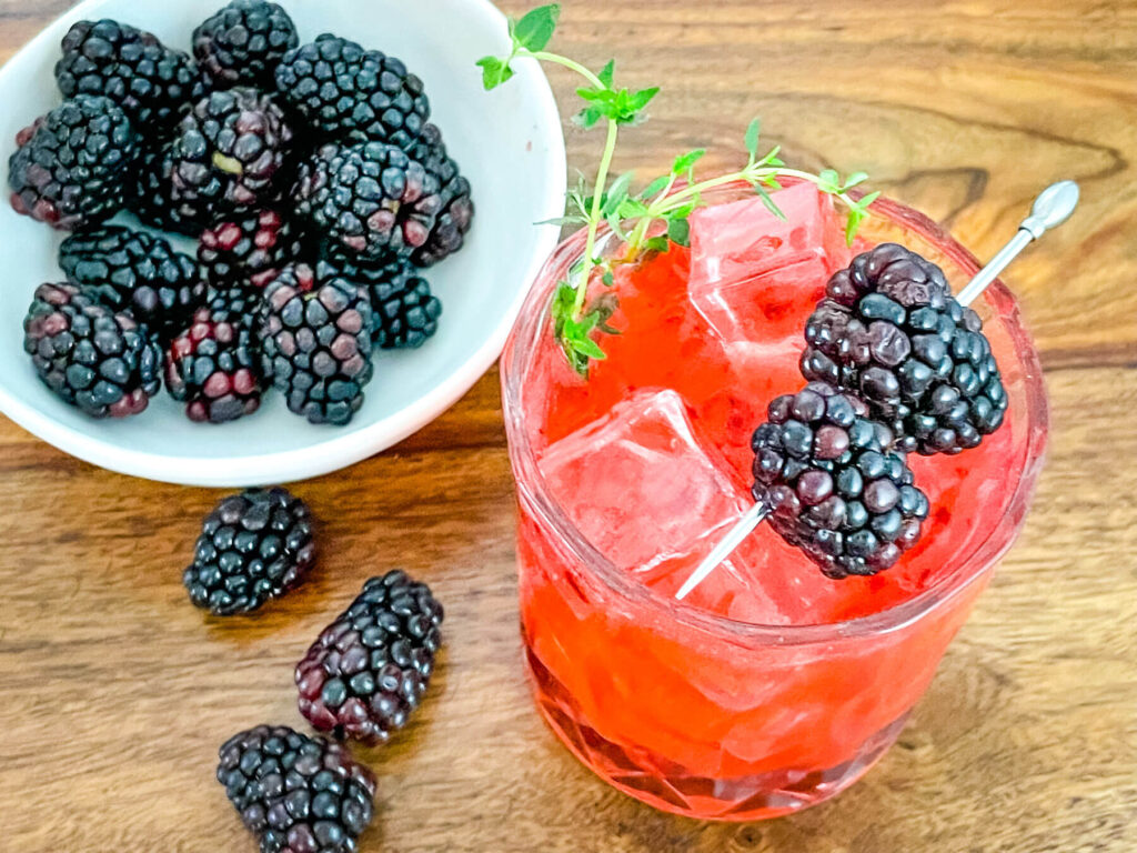 Top view of a Blackberry Bourbon Sidecar with a bowl of blackberries next to it