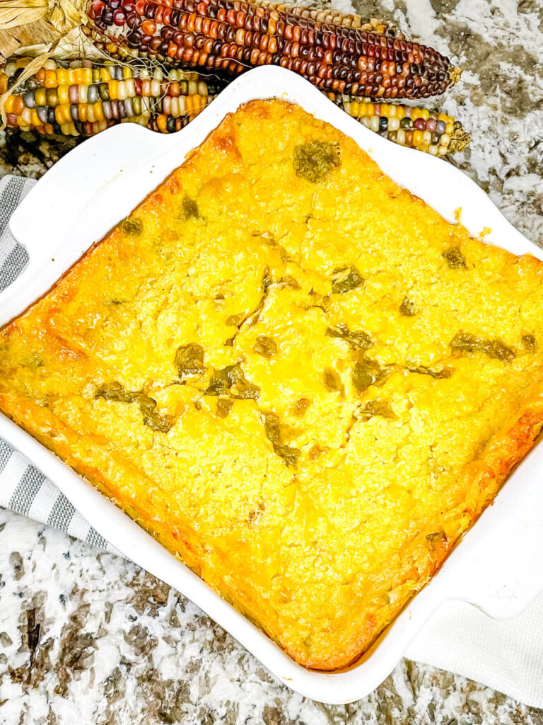 Green Chile Cornbread Casserole in a square white baking dish