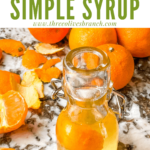 Pin of Orange Simple Syrup in a small bottle with oranges around it and title at top