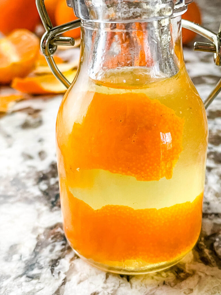 Close up of Orange Simple Syrup in a small bottle