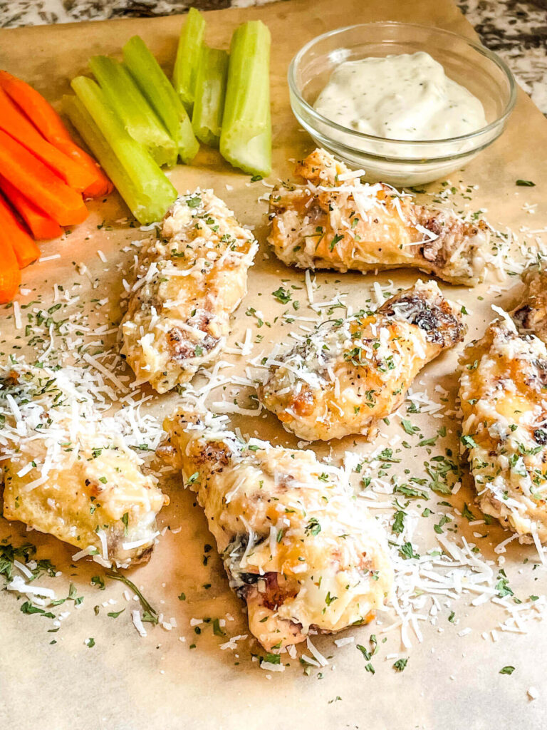 Parmesan Garlic Chicken Wings on butcher paper with celery and carrots