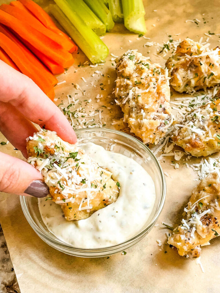 A hand dunking a piece into sauce