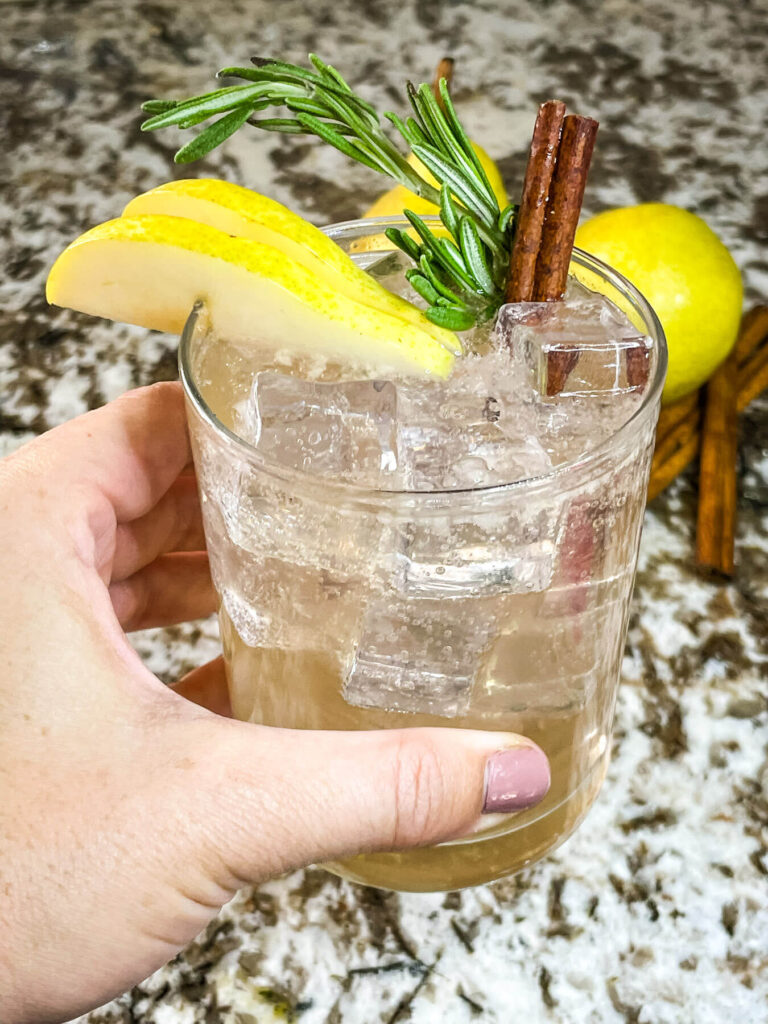 A hand holding a Pear Tree Vodka Cocktail