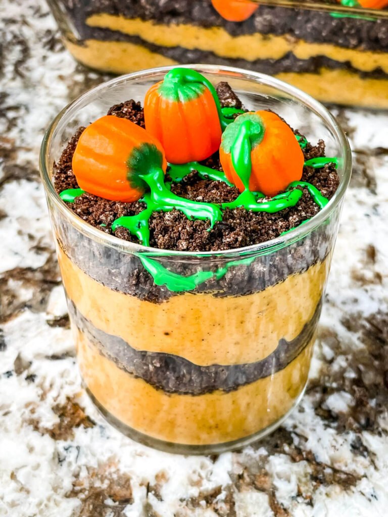 A single portion of Pumpkin Patch Dirt Pudding Dessert in a clear cup