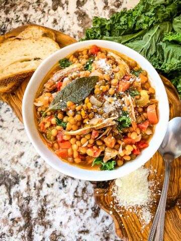 Top view of Turkey Lentil Soup in a white bowl on a wood board