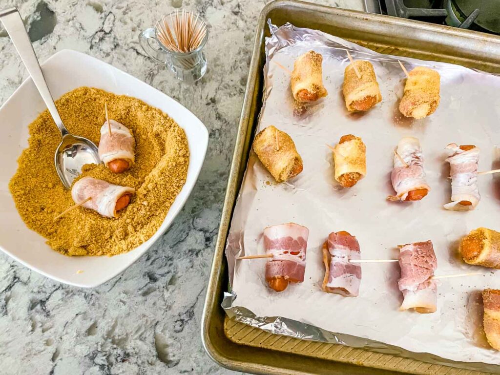 The rolled sausages being dunked into the sugar