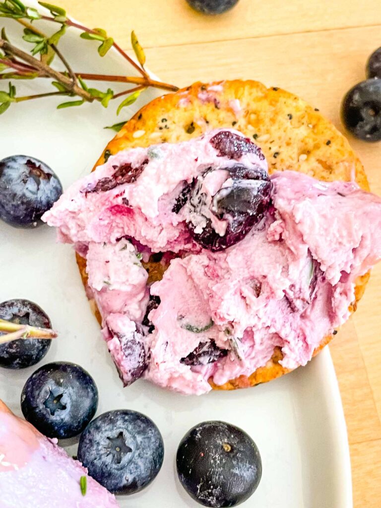 A cracker with Blueberry Goat Cheese on it