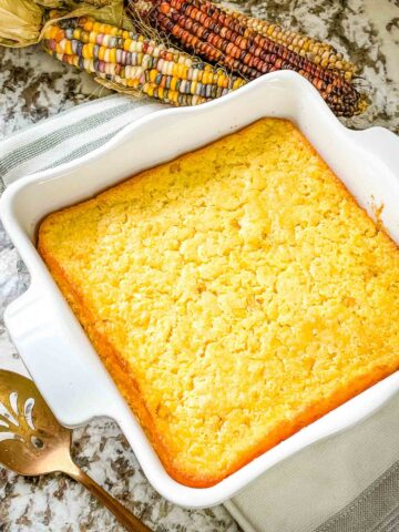 A finished Corn Casserole in a white square dish