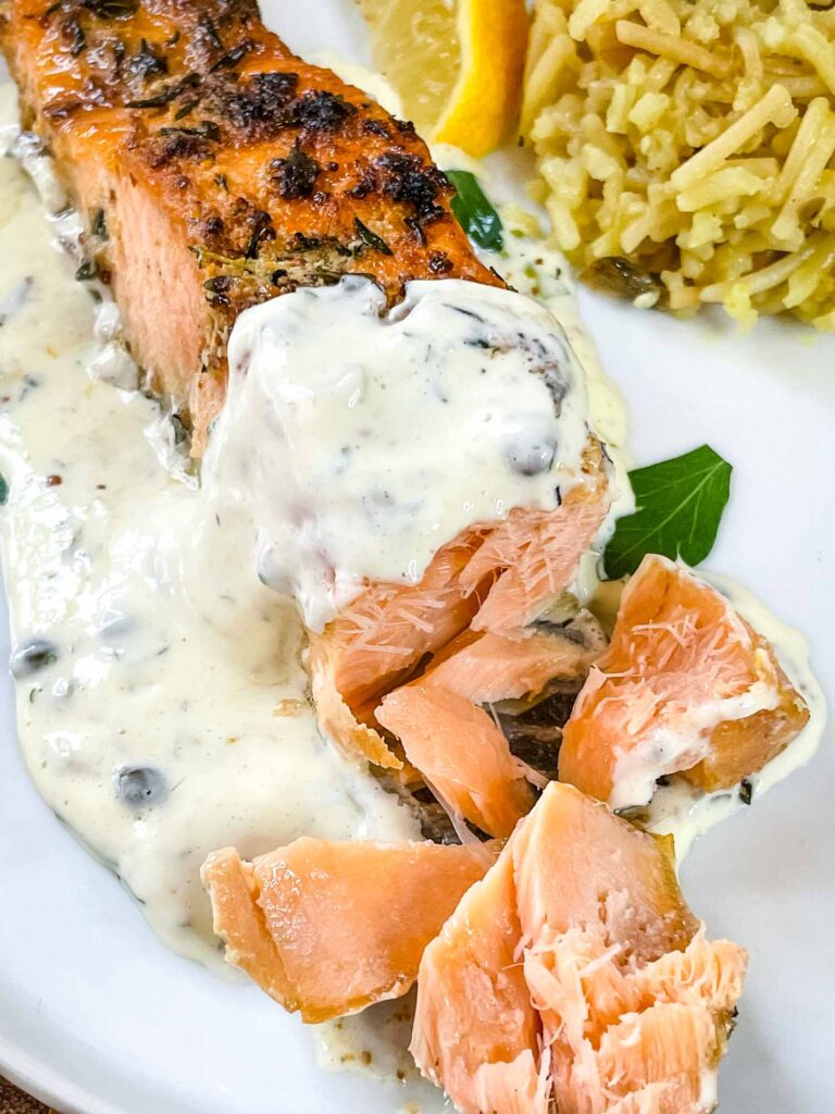 A piece of fish cut into with remoulade sauce