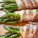 The asparagus bacon bundles lined up on a baking sheet
