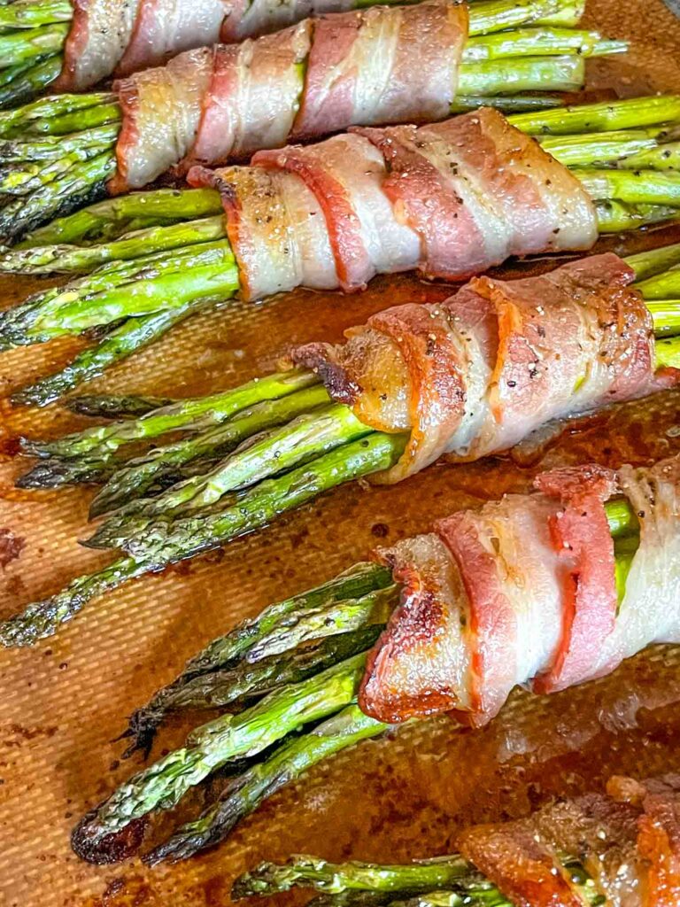 Asparagus Wrapped in Bacon on a baking sheet