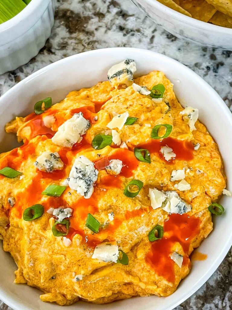 Top view of Buffalo Chicken Crockpot Dip in a small white bowl