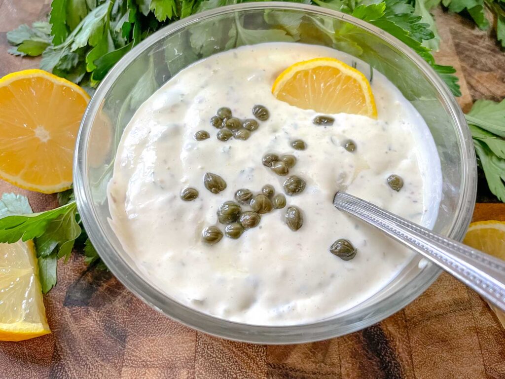 The sauce in a bowl with capers and a lemon wedge on top
