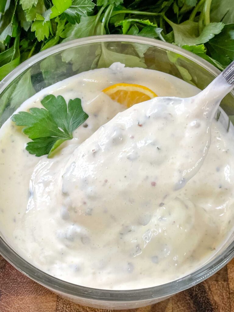 A spoon scooping Remoulade Sauce out of a dish
