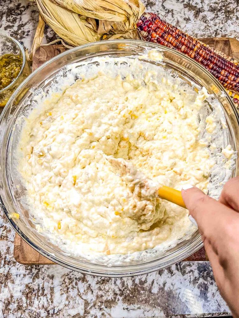 A hand mixing the ingredients together in a bowl