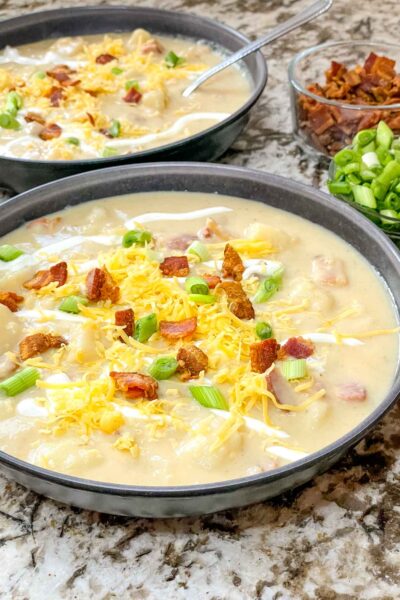 Two bowls of Instant Pot Potato Soup with toppings
