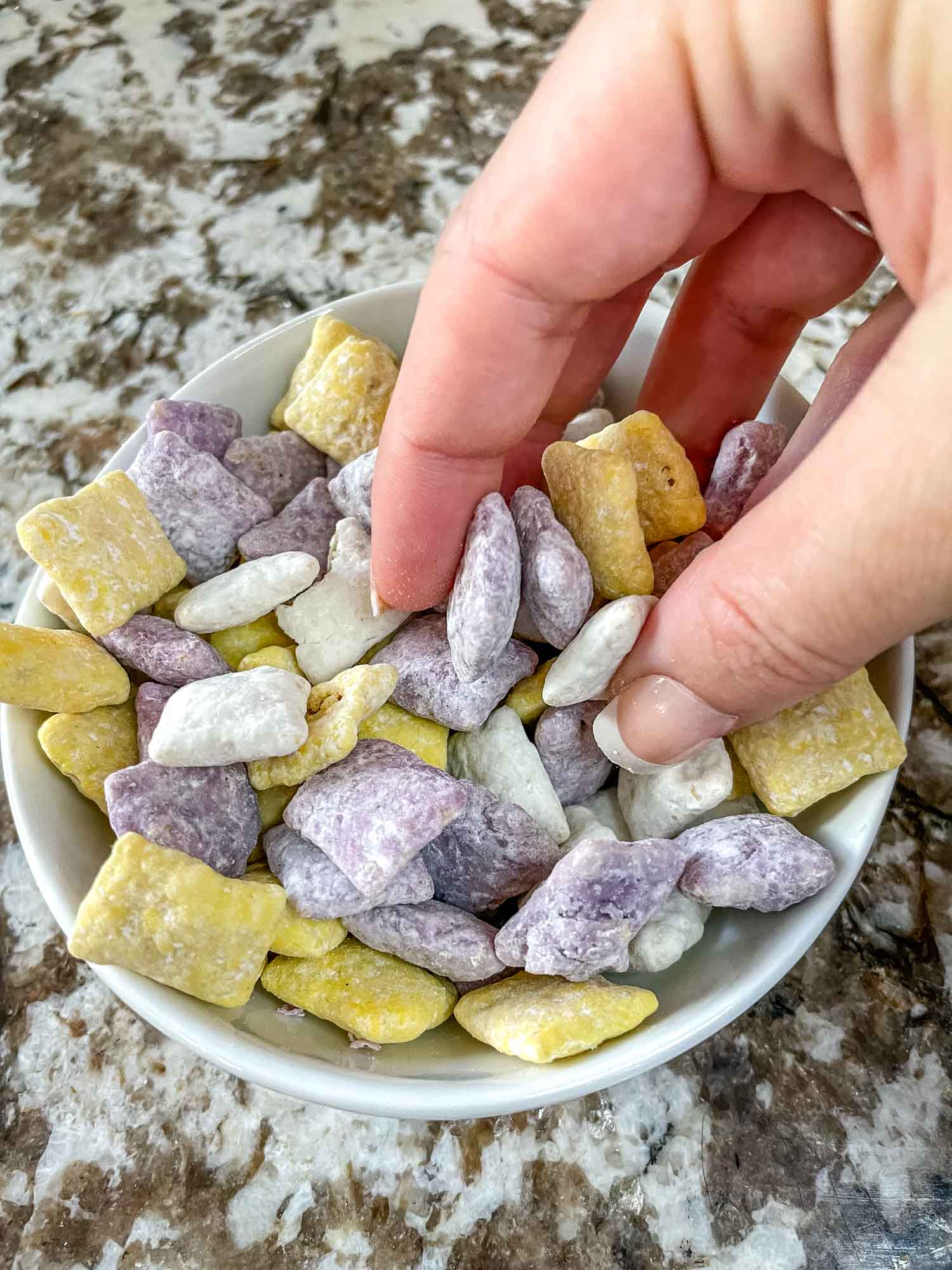 A hand grabbing Minnesota Vikings Puppy Chow out of a bowl