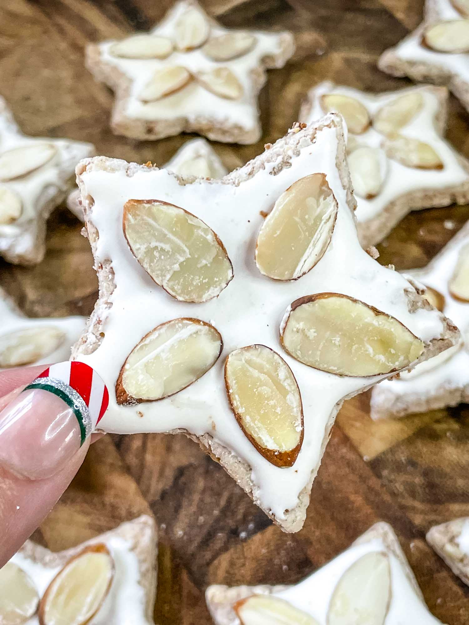 A hand holding a Zimmerstern (German Cinnamon Star Cookies)