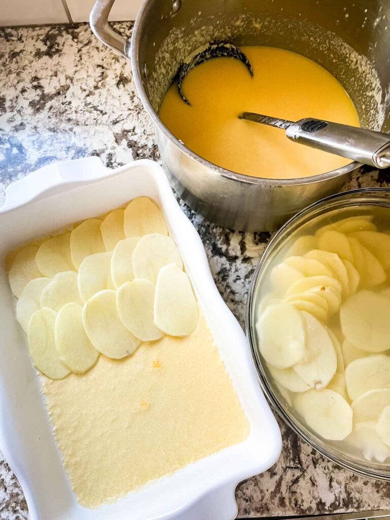 Assembly shot of making the Scalloped Cheesy Potatoes