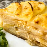 Side view of a portion of Scalloped Cheesy Potatoes on a plate