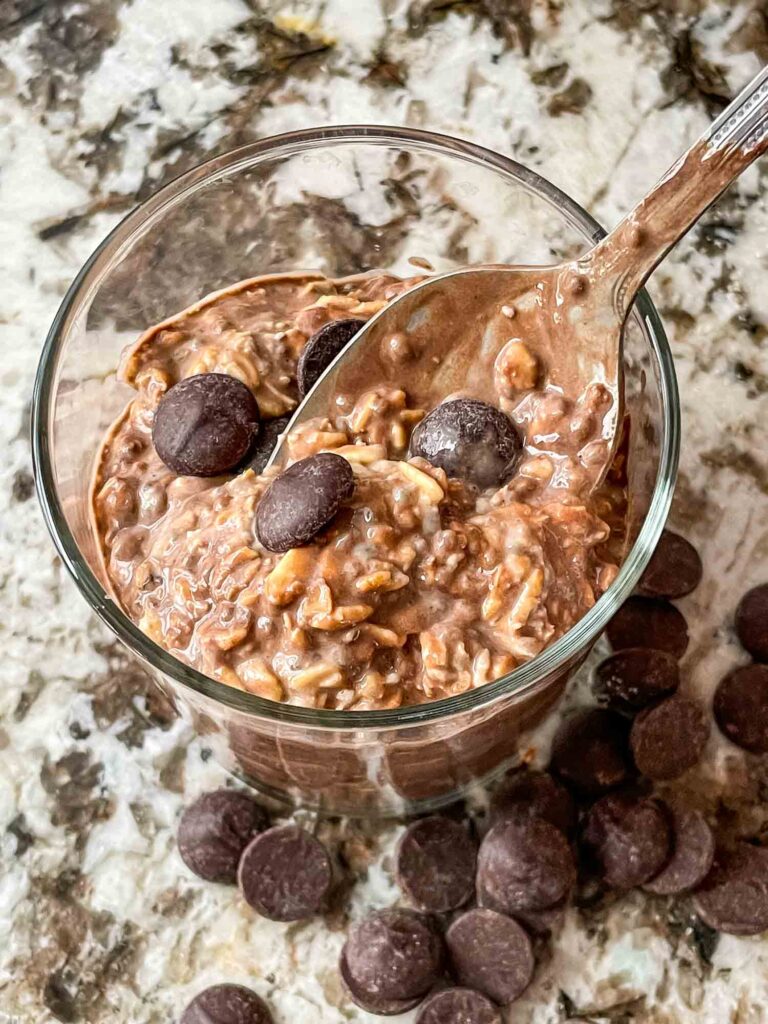 A spoon digging into a jar of Chocolate Overnight Oats