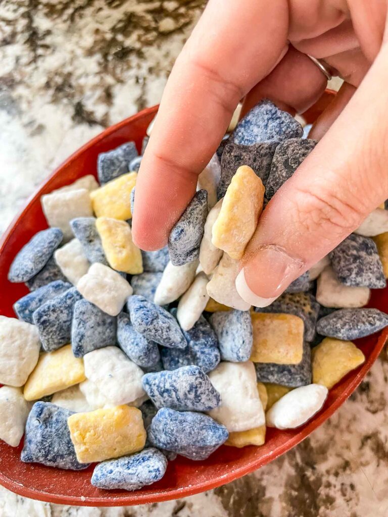 A hand grabbing some Los Angeles Rams Puppy Chow out of a football bowl